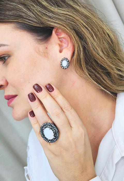Brinco Valquíria oval com pedra leitosa e strass hematite banhado no grafite