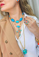 Mix de colares Brisa Tropical com crucifixo e pedras turquesas e coral banhado no dourado