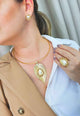 Colar Saraya de aro dourado com pingente de folha com perola e strass