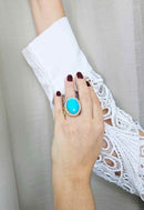 Anel Nina oval com pedras azul turquesa e cristal banhado no dourado