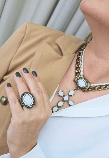 Anel Fascínio oval com pedra branca e hematite banhado no ouro velho