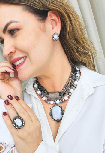 Brinco Valquíria oval com pedra leitosa e strass hematite banhado no grafite