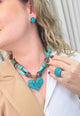 Colar Noir de pedras marrom e verde com pingente de coração blue zircon banhado no ouro velho
