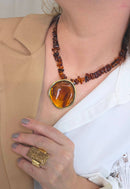 Colar Flamboyant com pingente dourado e cascalhos de resina amarronzadas no banho dourado