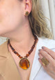 Colar Flamboyant com pingente dourado e cascalhos de resina amarronzadas no banho dourado