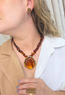 Colar Flamboyant com pingente dourado e cascalhos de resina amarronzadas no banho dourado