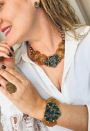 Colar Sublime com resinas marrons e pedras verde esmeralda banhado no ouro velho