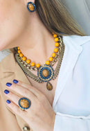 Maxi Colar Expressão com pingente oval e pedras azuis e mostrada banhado no ouro velho