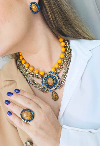 Maxi Colar Expressão com pingente oval e pedras azuis e mostrada banhado no ouro velho