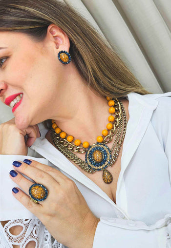 Maxi Colar Expressão com pingente oval e pedras azuis e mostrada banhado no ouro velho