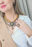 Maxi Colar Expressão com pingente oval e pedras azuis e mostrada banhado no ouro velho