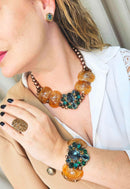 Pulseira Sublime com resinas marrons e pedras verde esmeralda banhado no ouro velho